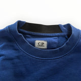 Détail du col rond bleu en coton de Secondstore C.P. COMPANY avec étiquette de marque et bordure contrastante