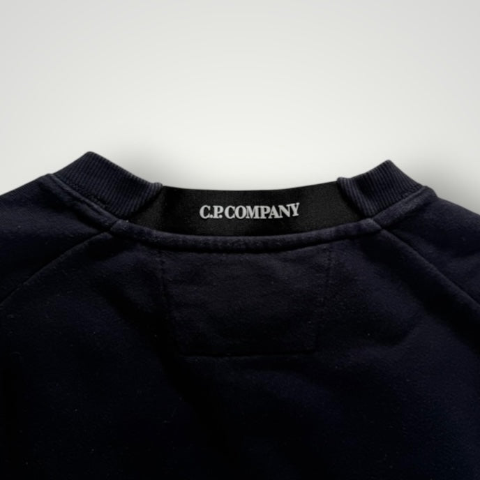 Détail du col rond et étiquette de marque Secondstore C.P. Company sur un sweat-shirt en coton bleu marine