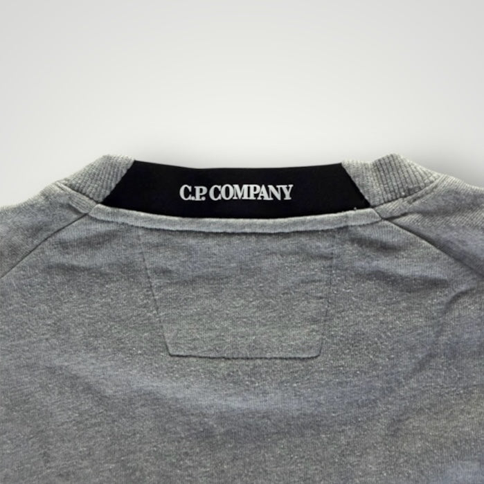 Gros plan sur le col rond gris chiné d'un sweat-shirt Secondstore C.P. Company avec logo intérieur contrastant