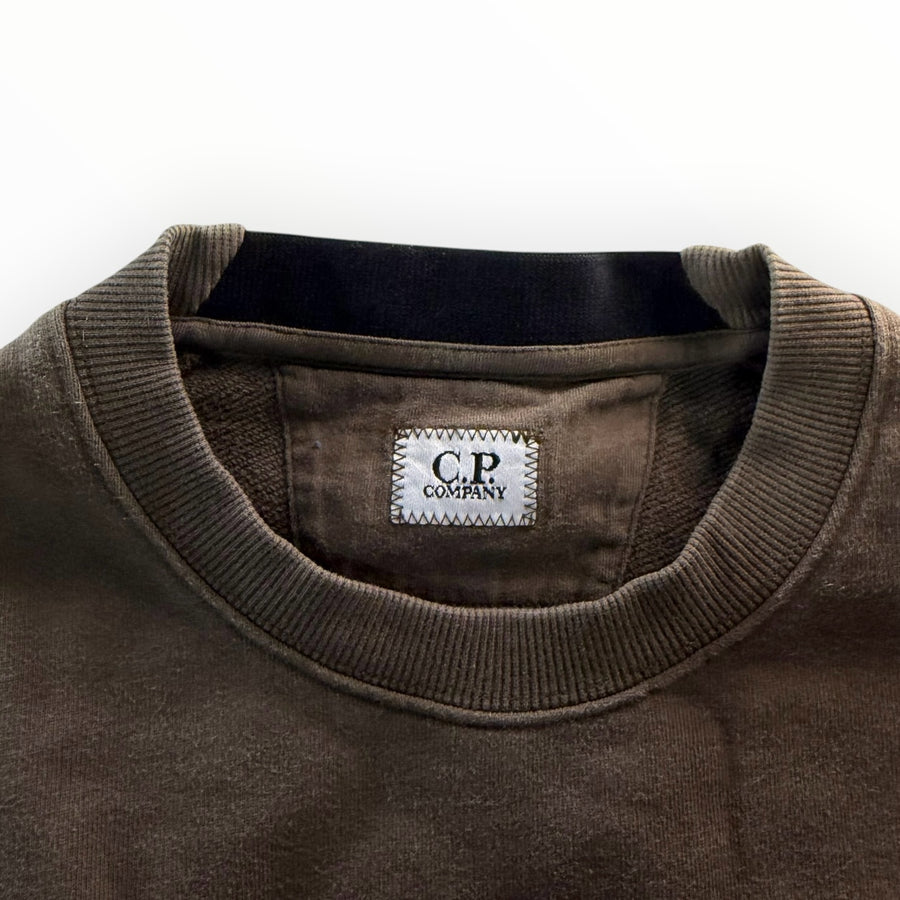 Détail du col rond et étiquette de marque Secondstore C.P. COMPANY sur un sweat-shirt en coton kaki