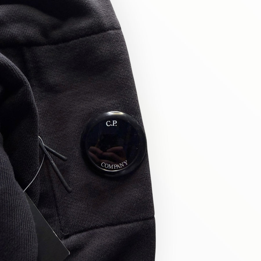 Détail de la lentille signature noire sur la manche d'un sweat-shirt Secondstore C.P. Company en coton