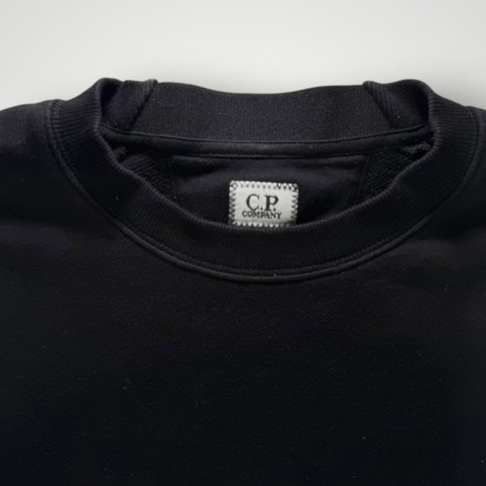 Gros plan sur le col rond noir en coton du sweat-shirt Secondstore C.P. Company avec étiquette de marque visible