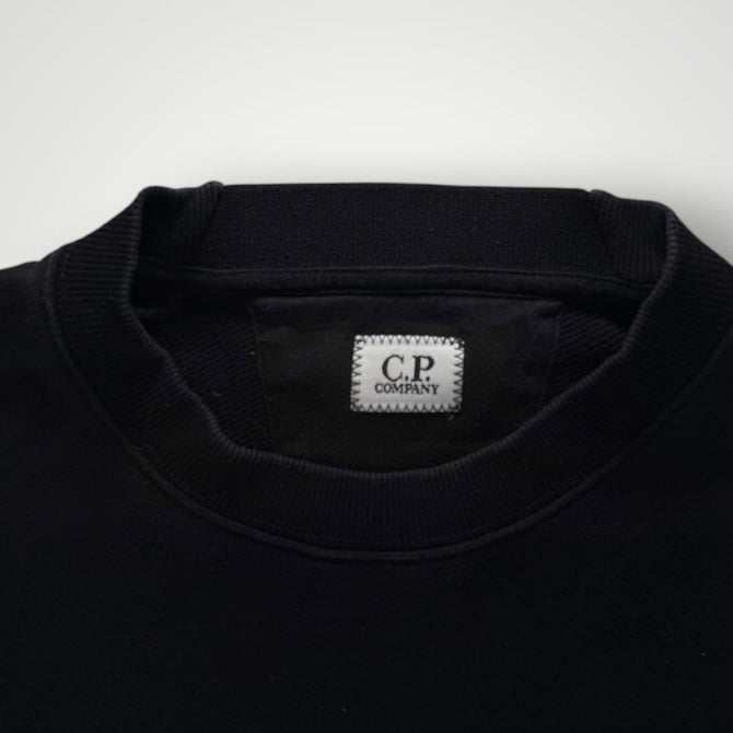 Gros plan sur le col rond noir en coton du sweat-shirt Secondstore C.P. Company avec étiquette de marque intérieure