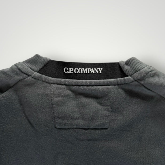 Gros plan sur le col rond gris en coton d'un sweat-shirt Secondstore C.P. COMPANY avec étiquette de marque visible