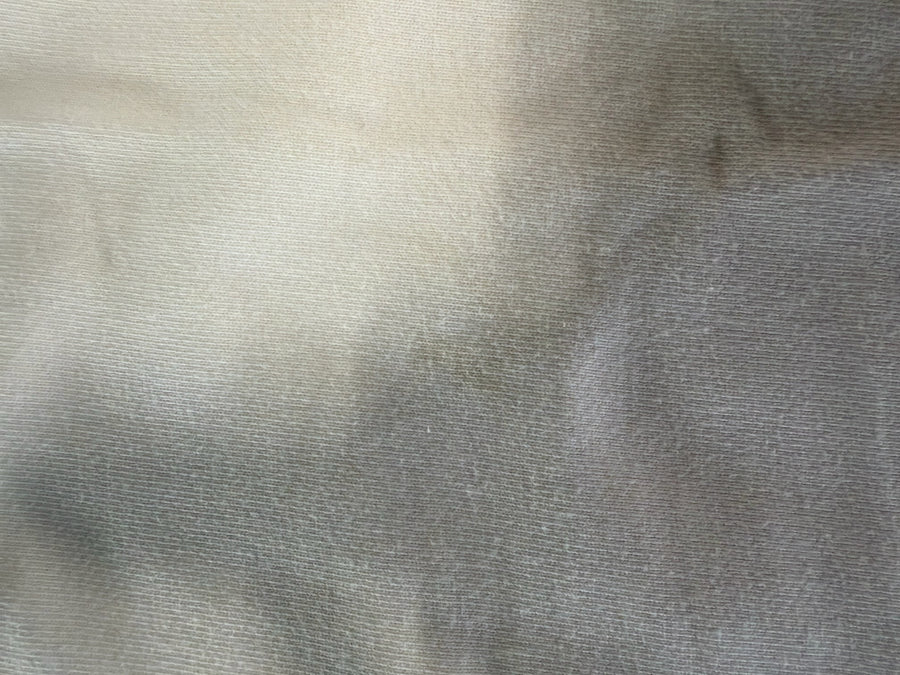 Gros plan sur le tissu en coton blanc du sweat-shirt Secondstore C.P. Company montrant la texture douce et la maille