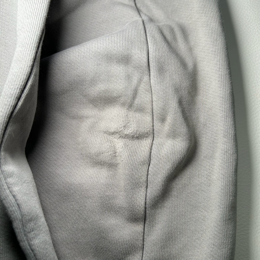 Gros plan sur le tissu en coton gris du sweat-shirt Secondstore C.P. Company avec couture détaillée