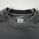 Gros plan sur le col rond côtelé d'un sweat-shirt gris Secondstore C.P. COMPANY en coton avec étiquette intérieure