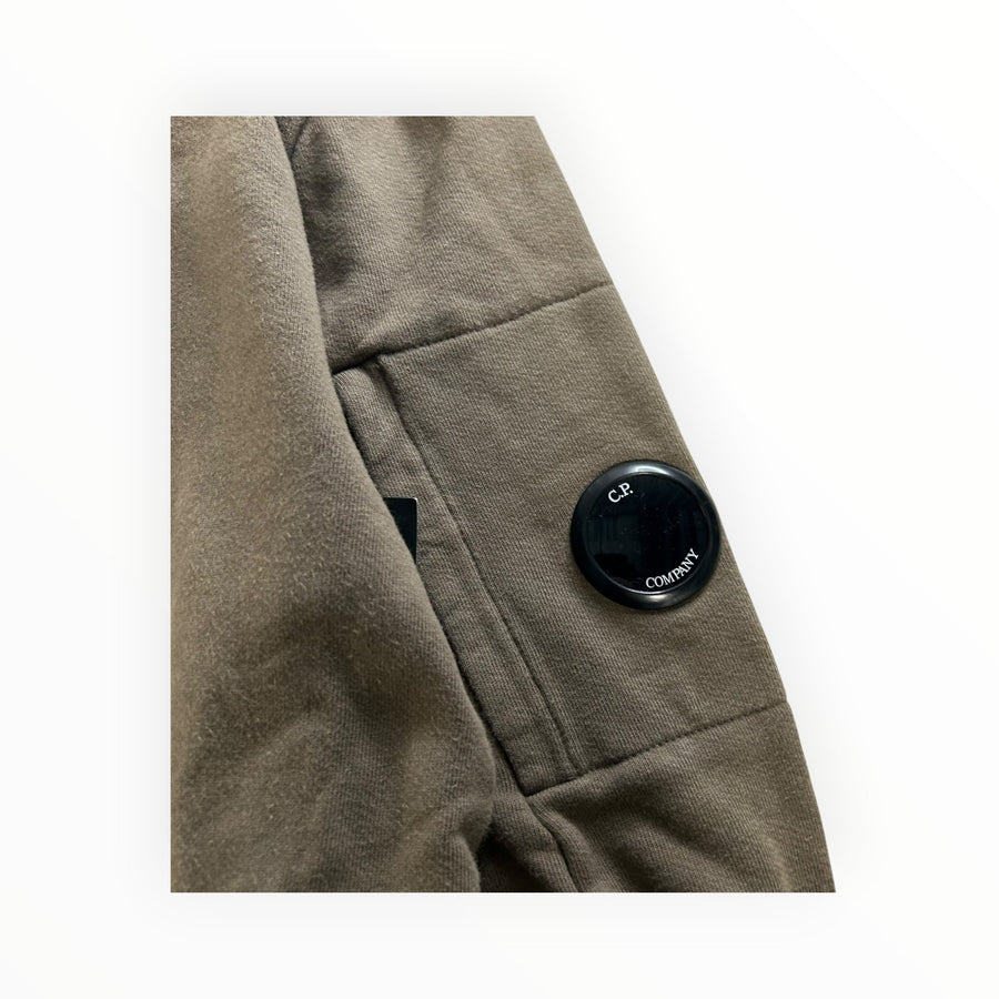 Secondstore C.P. Company olive-khaki cotton sweatshirt sleeve featuring the signature black lens utility pocket detail.