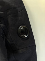 Détail de la lentille signature noire sur la manche d'un sweatshirt en coton Secondstore C.P. Company