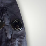 Détail de la lentille signature noire sur la manche d'un sweat-shirt gris anthracite Secondstore C.P. Company en coton