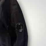 Détail de la manche noire en coton du sweat-shirt Secondstore C.P. COMPANY avec sa lentille emblématique zippée