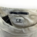 Gros plan sur le col d'un t-shirt beige Secondstore C.P. Company avec étiquette Box Fit et logo brodé