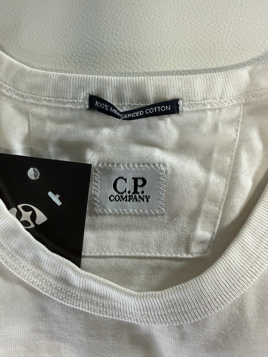 Gros plan sur l'étiquette intérieure d'un t-shirt Secondstore C.P. Company en coton mercerisé beige