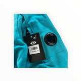 Secondstore C.P. Company teal cotton sweatshirt sleeve featuring the iconic black lens detail and brand tag