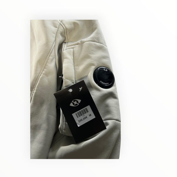 Veste Secondstore C.P. Company beige en soft shell avec poche zippée sur la manche et détail signature iconique