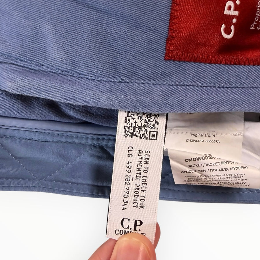 Étiquette d'authenticité Secondstore à l'intérieur d'une veste bleue C.P. Company avec code QR et détails techniques