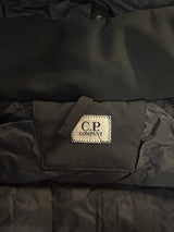 Étiquette de marque C.P. Company sur une veste noire technique Secondstore, détail de couture et tissu matelassé.