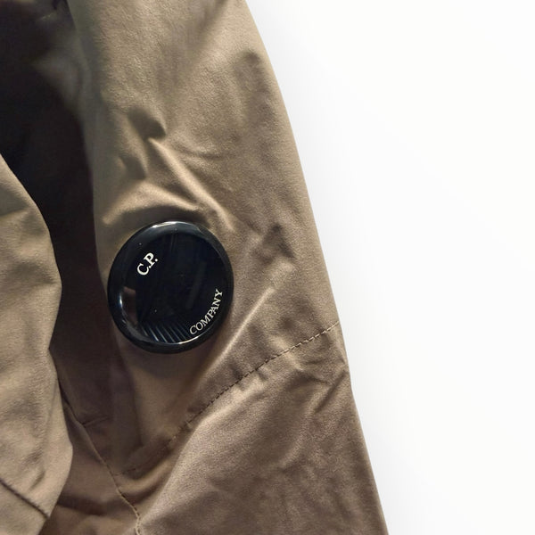 Détail de la manche d'une veste technique Secondstore C.P. Company en tissu Pro-Tek beige avec le logo emblématique