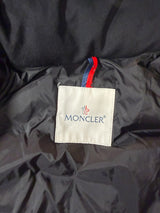 Étiquette intérieure de marque Moncler sur une doudoune noire Secondstore avec détails tricolores