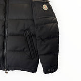 Doudoune noire Secondstore Moncler avec matelassage, fermeture zippée et écusson emblématique sur la manche