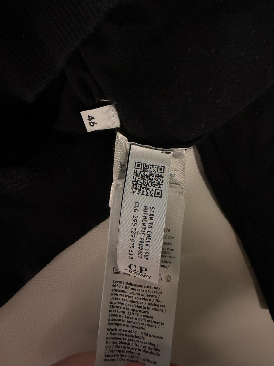 Étiquette intérieure d'authenticité Secondstore sur un pull noir C.P. Company avec code QR et instructions de lavage