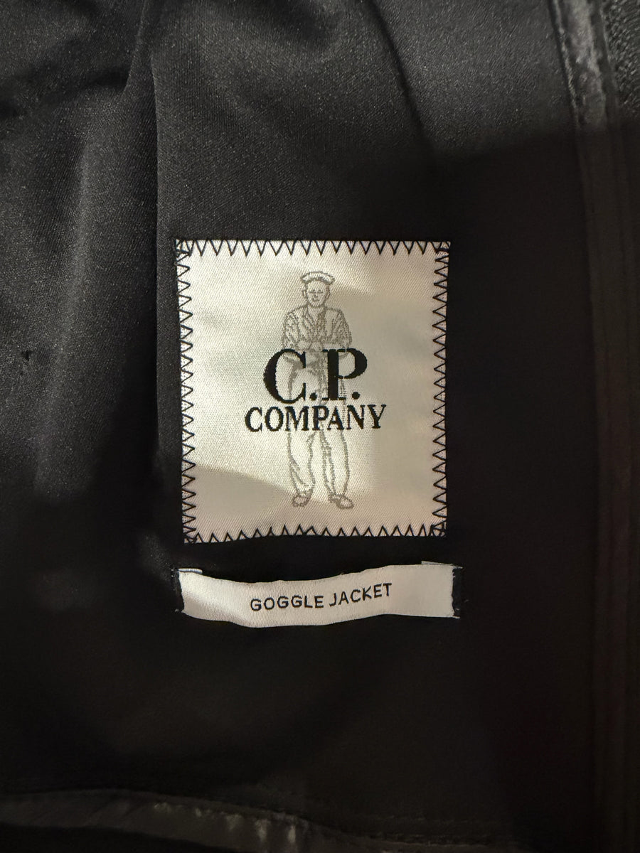 Étiquette intérieure de marque Secondstore sur une veste noire C.P. Company Goggle Jacket avec logo et inscription