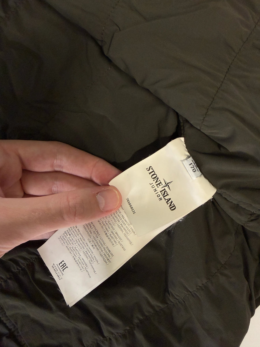 Étiquette intérieure de composition et logo Stone Island Junior sur un gilet vert olive chez Secondstore