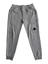 Secondstore grey C.P. Company jogging pants with a side cargo pocket and signature lens detail on a white background