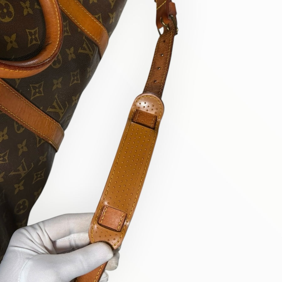 Détail de la bandoulière en cuir de vachette naturel du sac de voyage Secondstore Louis Vuitton Keepall en toile Monogram
