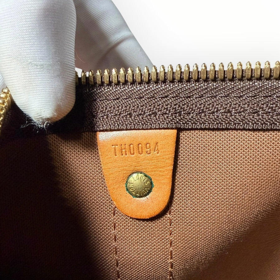 Détail intérieur du sac de voyage Secondstore Louis Vuitton Keepall avec étiquette en cuir et code date TH0094
