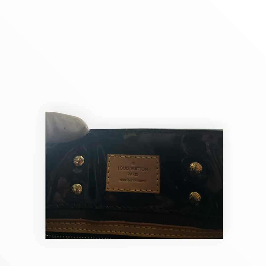 Détail intérieur du sac Secondstore Louis Vuitton en cuir verni noir avec étiquette de marque en cuir naturel