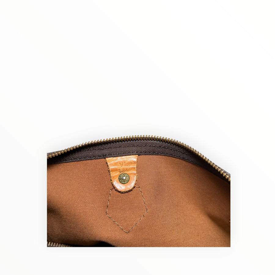 Détail intérieur du sac Secondstore Louis Vuitton Speedy avec doublure en toile marron et languette en cuir