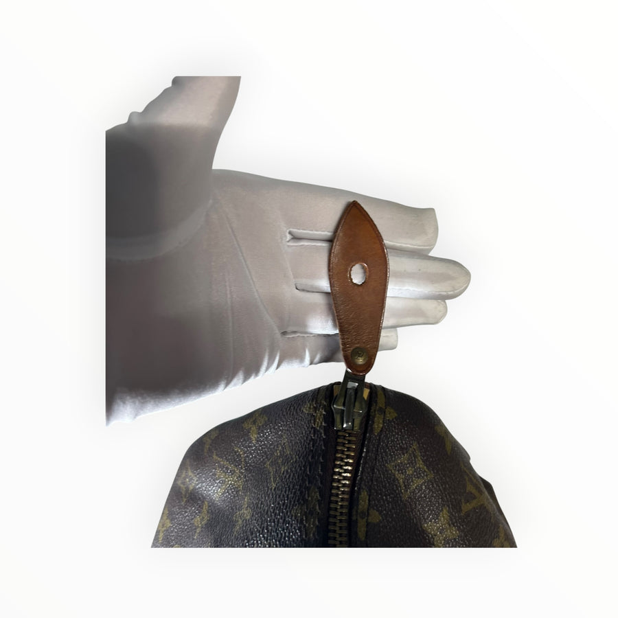 Détail de la tirette en cuir naturel sur le sac Secondstore Louis Vuitton Speedy en toile Monogram emblématique
