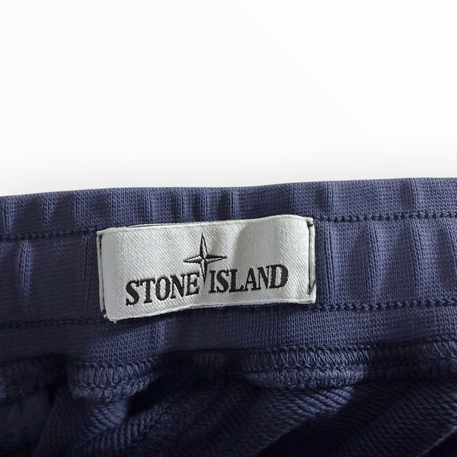 Étiquette de marque Stone Island cousue sur la ceinture élastique d'un pantalon de jogging bleu Secondstore