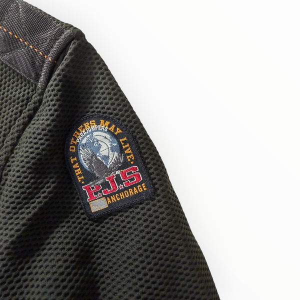 Gros plan sur le patch iconique Parajumpers sur la manche en maille texturée vert olive de la veste Secondstore