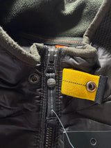 Détail de la fermeture éclair et de la languette jaune emblématique sur une veste hybride Secondstore Parajumpers