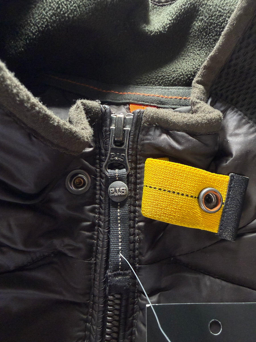 Détail de la fermeture éclair et de la languette jaune emblématique sur une veste hybride Secondstore Parajumpers