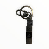 Porte-clés Secondstore Louis Vuitton en métal argenté sombre avec cubes géométriques gravés et mousqueton robuste