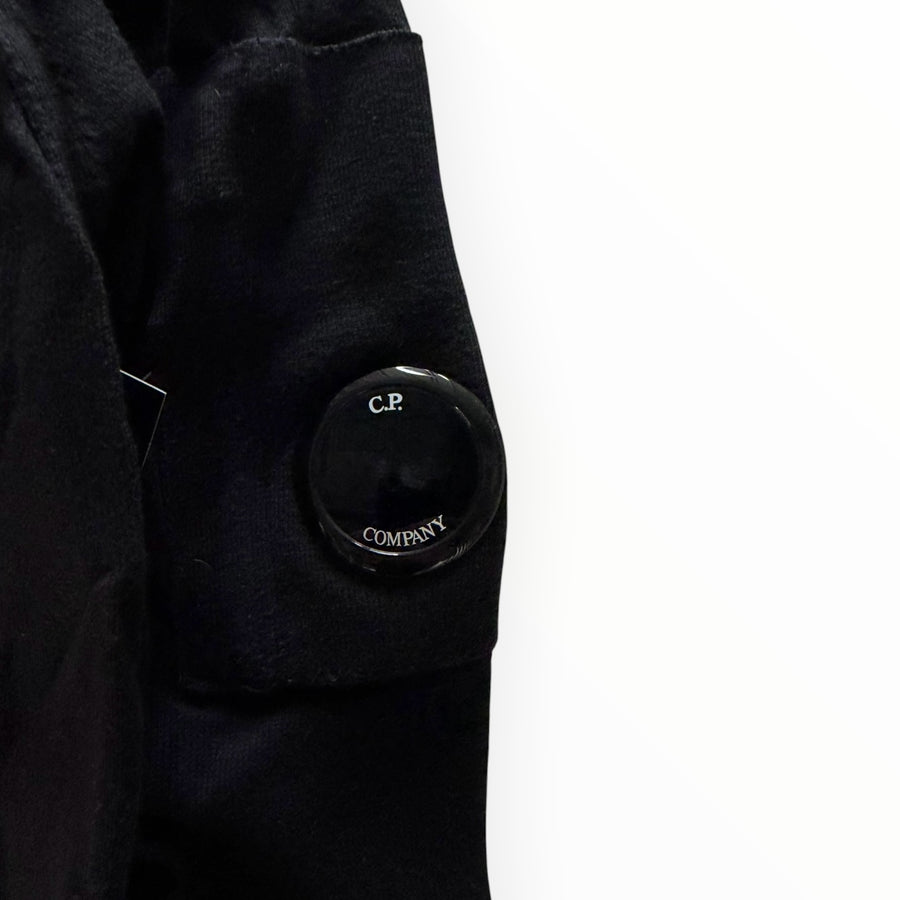Détail de la lentille iconique noire sur la manche d'un pull en coton Secondstore C.P. Company