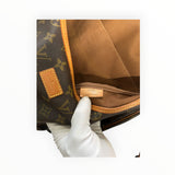 Détail intérieur du sac besace Secondstore Louis Vuitton en toile Monogram marron avec étiquette de fabrication