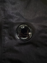 Détail de la lentille iconique noire sur un sac à dos en nylon Secondstore C.P. Company