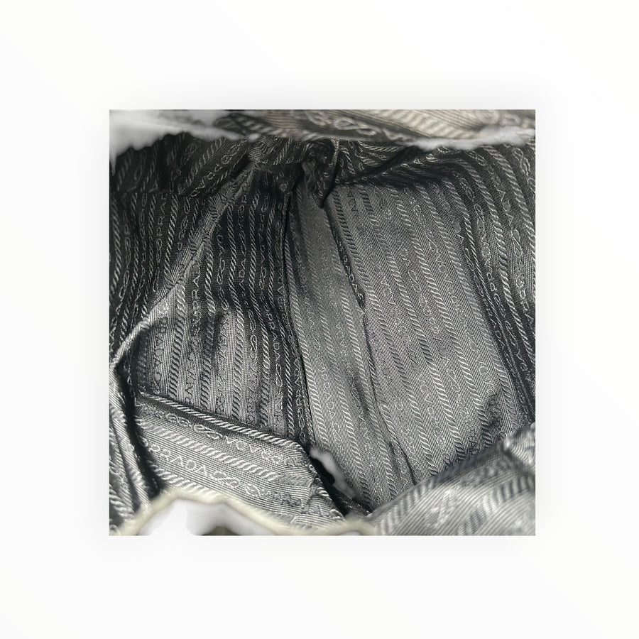 Intérieur du sac à dos Secondstore Prada en nylon noir avec doublure en tissu jacquard monogrammé signature