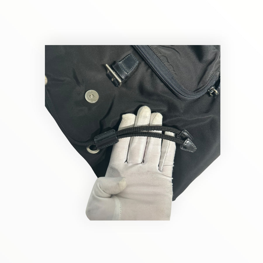 Détail du sac à dos Secondstore Prada en nylon noir avec cordon de serrage et boucle métallique