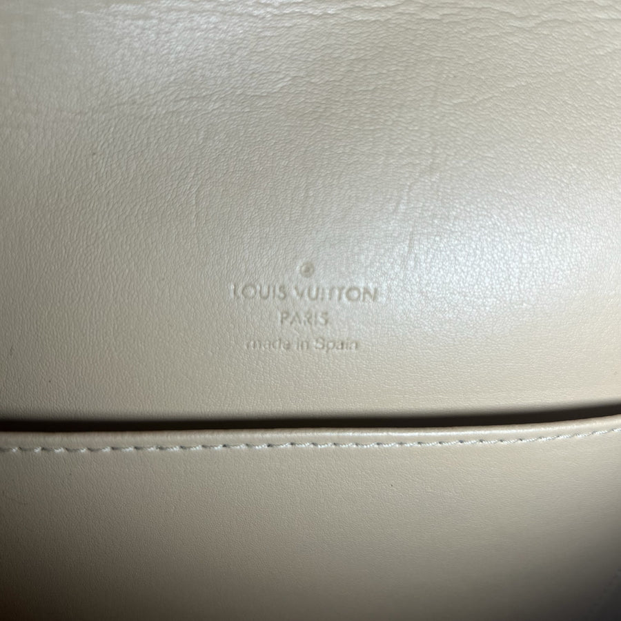 Gros plan sur le logo embossé Louis Vuitton à l'intérieur d'un sac Secondstore en cuir beige lisse