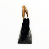 Sac à main Secondstore Louis Vuitton en cuir verni noir monogrammé avec anses en cuir naturel, vue de profil.