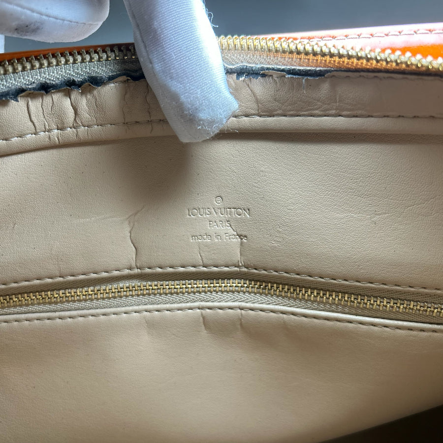 Gros plan sur l'intérieur en cuir beige d'un sac Secondstore Louis Vuitton Vernis avec marquage embossé