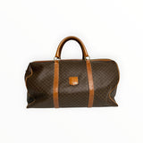 Sac de voyage Secondstore CELINE en toile enduite Macadam marron avec finitions en cuir miel et détails dorés.