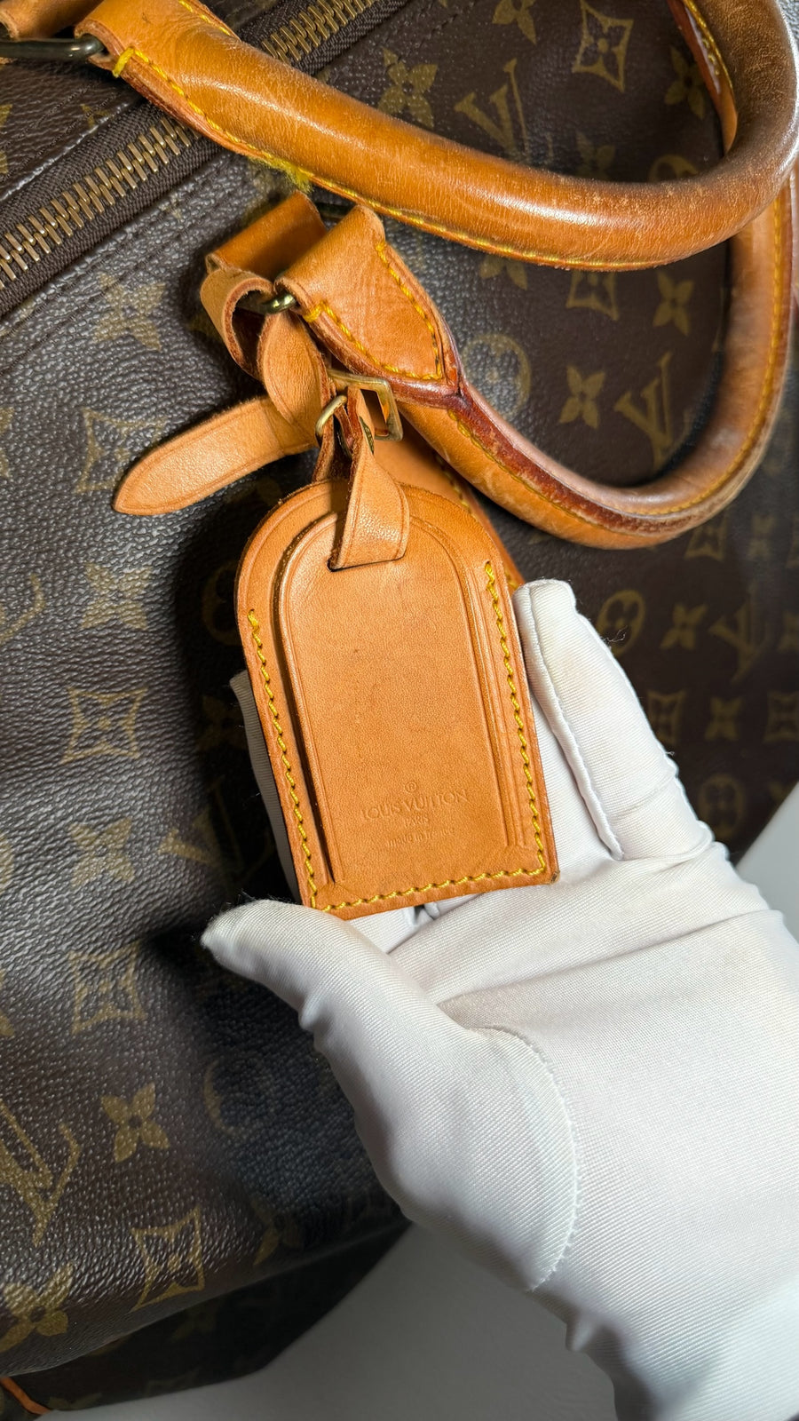 Étiquette d'identification en cuir naturel sur sac de voyage Louis Vuitton Keepall en toile Monogram chez Secondstore