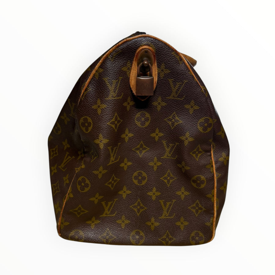 Vue latérale du sac de voyage Secondstore Louis Vuitton Keepall en toile Monogram avec cadenas et finitions en cuir