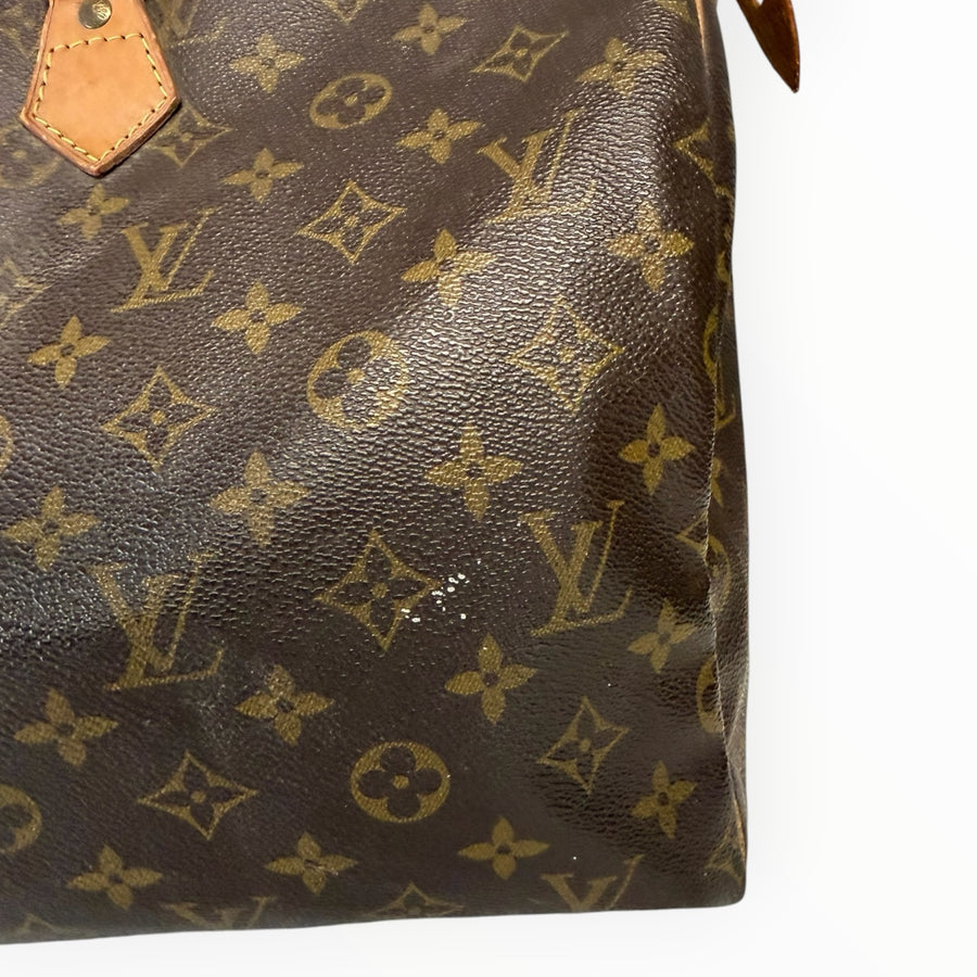 Gros plan sur la toile enduite Monogram marron du sac de voyage Secondstore Louis Vuitton Speedy avec détails en cuir